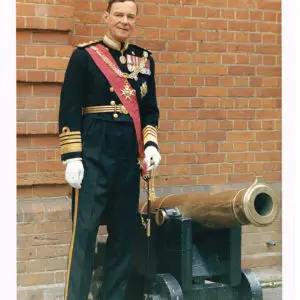 Colour photograph of Admiral Sir Charles Edward Madden in uniform beside a cannon