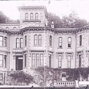 Sepia photograph of house frontage with two women sitting outside