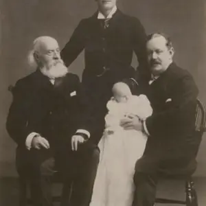 Black and white photograph of Sir Charles Cayzer, 1st Baronet, holding his grandson. Opposite, his father, and standing, his eldest son the 2nd Baronet